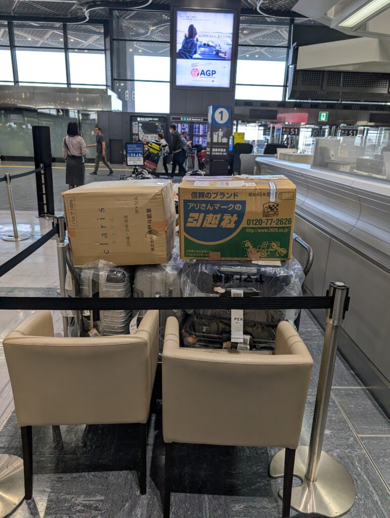 成田空港のチェックインカウンター前に積まれた我が家の荷物たち